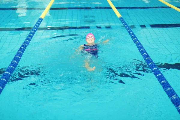 Ung kvinne som svømmer i basseng – stockfoto