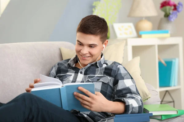 Jeune homme écoutant le livre audio à la maison — Photo