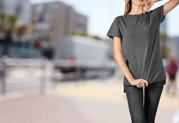 Jonge vrouw in stijlvolle t-shirt op stad straat — Stockfoto