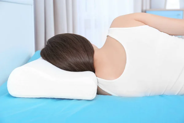Young woman with orthopedic pillow