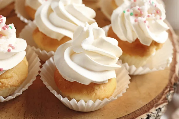 Houten standaard met smakelijke cupcakes — Stockfoto