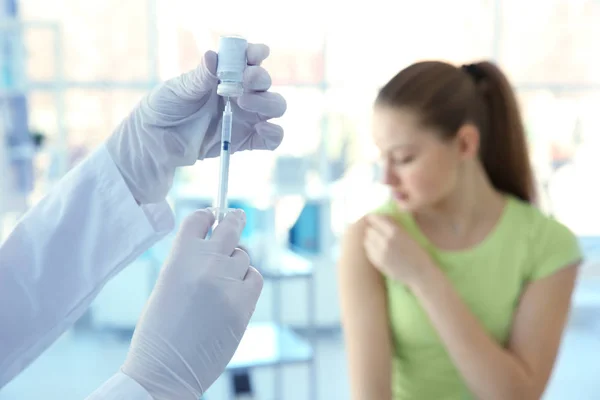 Rukou lékaře Příprava na očkování a rozmazané pacienta na pozadí — Stock fotografie