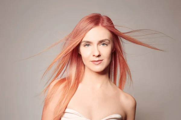 Mujer joven con pelo rubio fresa sobre fondo de color — Foto de Stock
