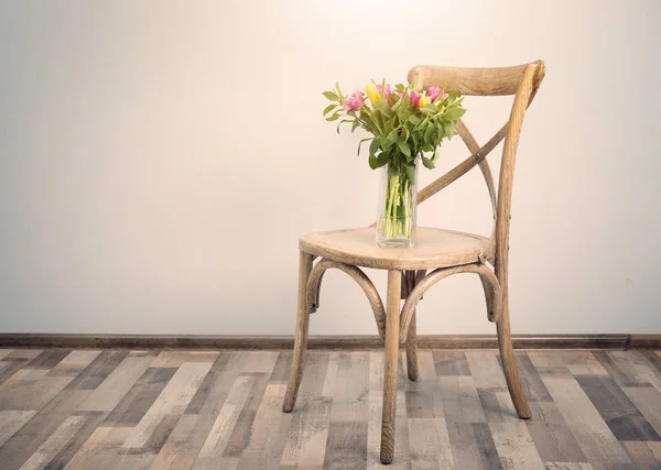 Chaise et vase avec bouquet de belles tulipes sur fond mural blanc — Photo