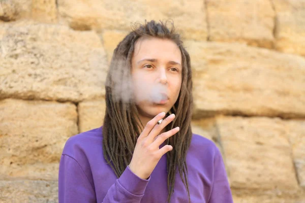 Young boy smoking weed on blurred background
