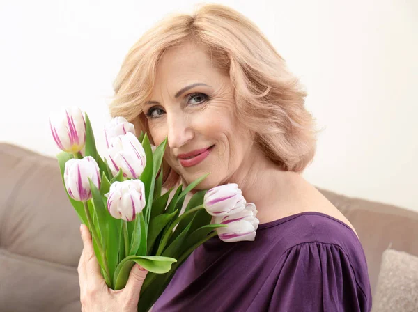 Mooie oudere vrouw met bloemen — Stockfoto