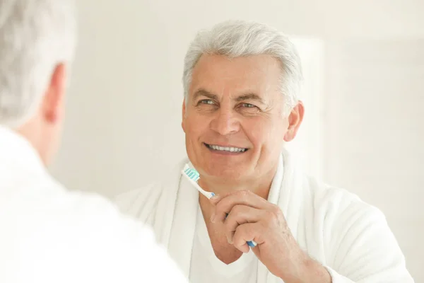 Hombre mayor limpiando dientes — Foto de Stock