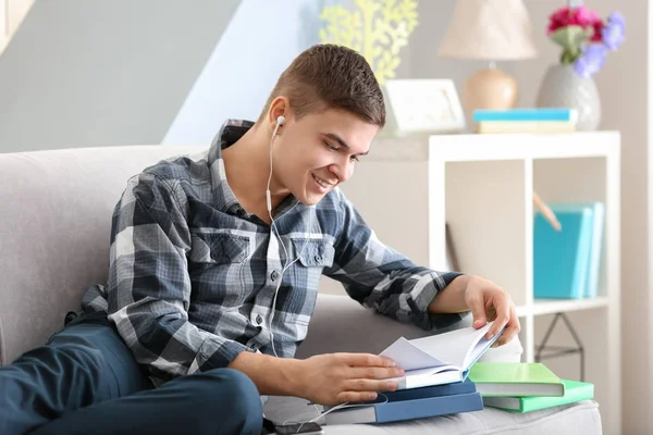 Junger Mann hört zu Hause Hörbuch — Stockfoto