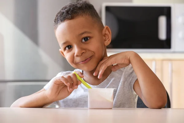 African American boy eating yogurt — Stock Photo, Image