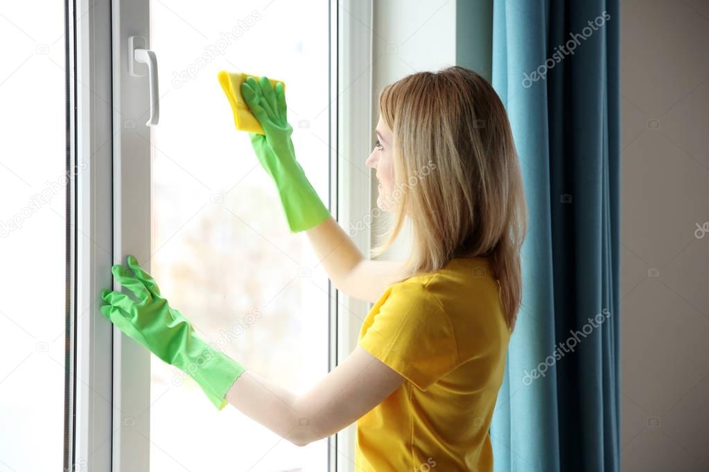 Young woman cleaning window