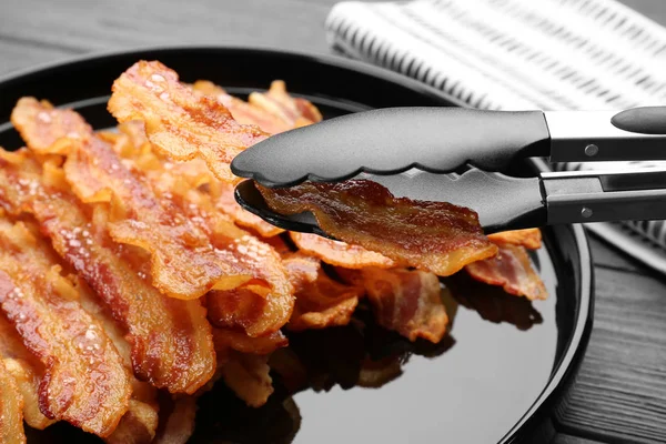 Tenant savoureuse tranche de bacon — Photo