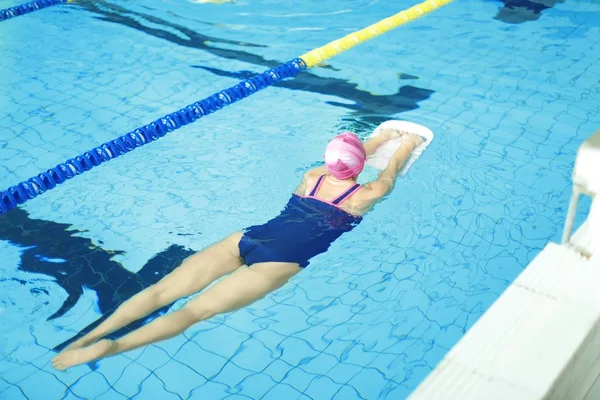 Jonge vrouw zwemmen in het zwembad — Stockfoto