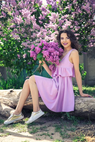Vrouw met boeket van lila — Stockfoto