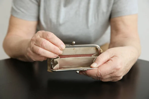 Senior woman with purse sitting at table, closeup. Poverty concept — Stock Photo, Image