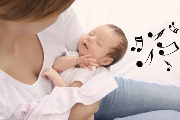 Mor med sovande barnet hemma. Lullaby låtar och musik koncept — Stockfoto