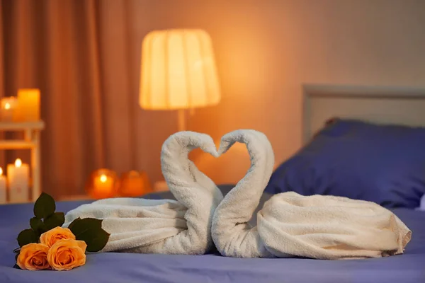 Twee zwanen gemaakt van handdoeken op bed — Stockfoto