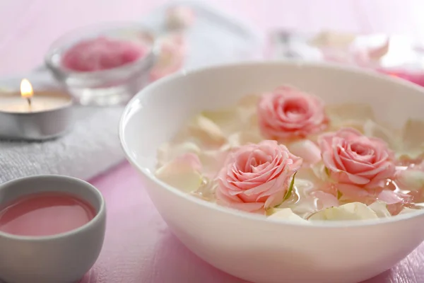 Ciotola con petali di fiori sull'acqua — Foto Stock