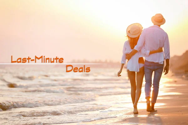 Travel deals concept. Young couple walking on beach