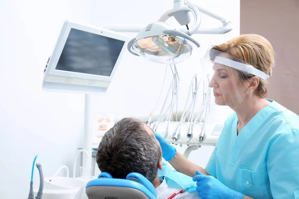 Dentist examining patient's teeth in clinic — Stock Photo, Image