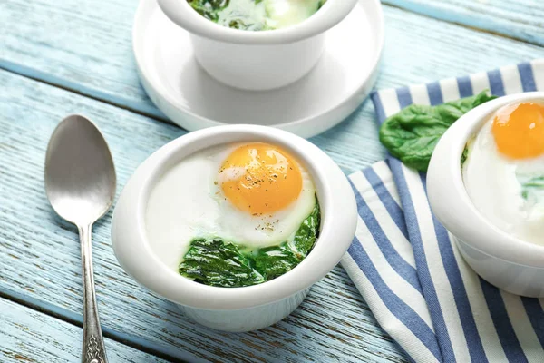 Skålar med välsmakande ägg och spenat — Stockfoto