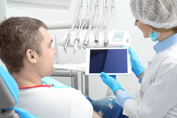 Zahnarzt mit Tablette und männlicher Patient in Klinik — Stockfoto