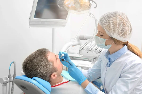 Dentist examining patient's teeth in clinic — Stock Photo, Image