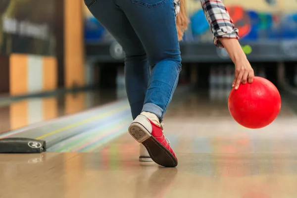 Jovem mulher jogando bola no bowling clube — Fotografia de Stock