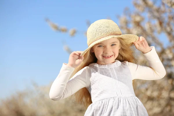 Klein meisje in de buurt van bloeiende boom — Stockfoto