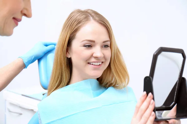 Young woman checking result of dental treatment — Stock Photo, Image