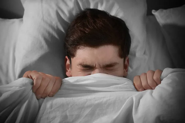 Наляканий чоловік у ліжку — стокове фото