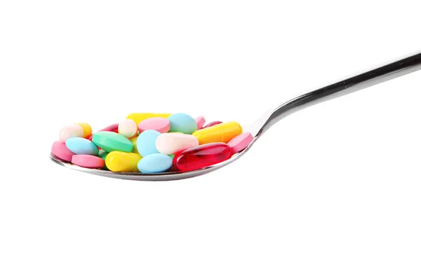 Spoon with colored pills — Stock Photo, Image