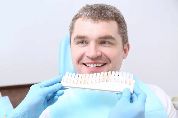 Zahnarzt überprüft und wählt die Farbe der Zähne des Mannes — Stockfoto