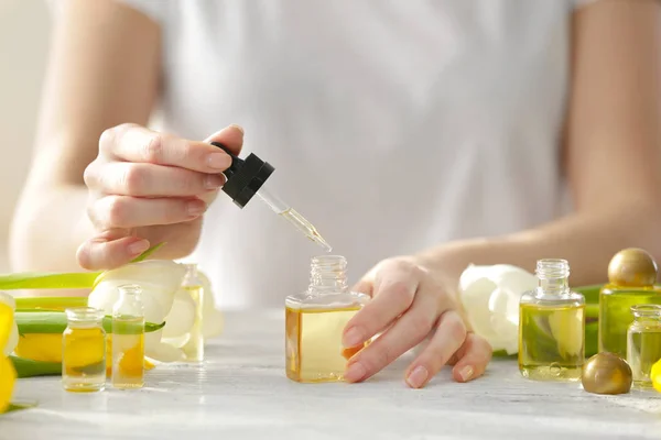 Woman dripping oil into bottle — Stock Photo, Image