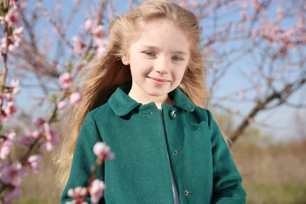 Klein meisje in de buurt van bloeiende boom — Stockfoto