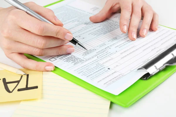 Woman filling form of Individual Income Tax Return, closeup — Stock Photo, Image