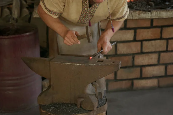 Smith working with iron in the forge