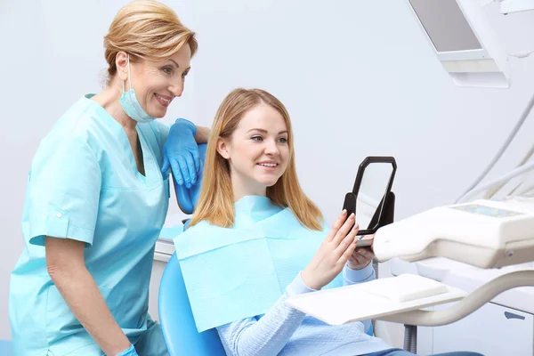 Young woman checking result of dental treatment — Stock Photo, Image