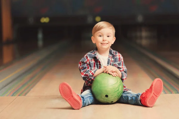 Słodkie dziecko z piłką w bowling club — Zdjęcie stockowe