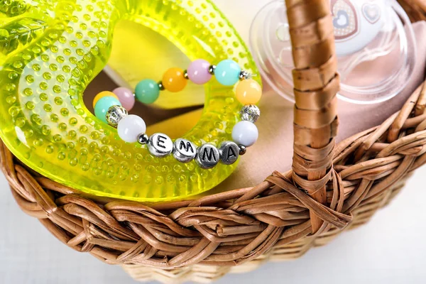 Bracelet with baby name Emma in basket — Stock Photo, Image