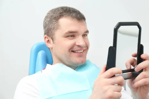 Homme vérifiant le résultat du traitement dentaire — Photo