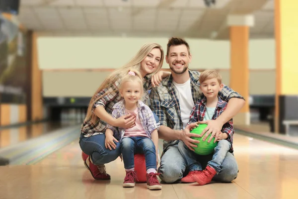 Glückliche Familie sitzt im Kegelclub auf dem Boden — Stockfoto