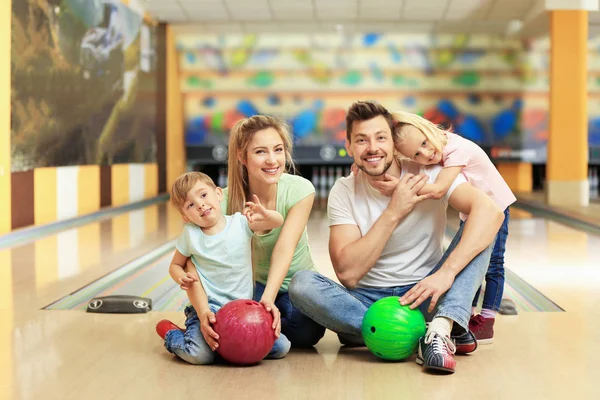 Keluarga bahagia duduk di lantai di klub bowling — Stok Foto