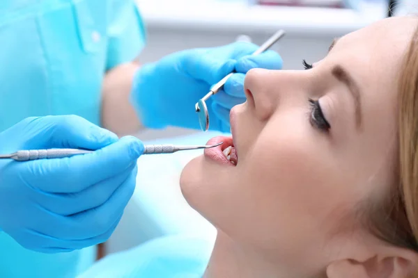 Dentista examinando los dientes del paciente en la clínica — Foto de Stock