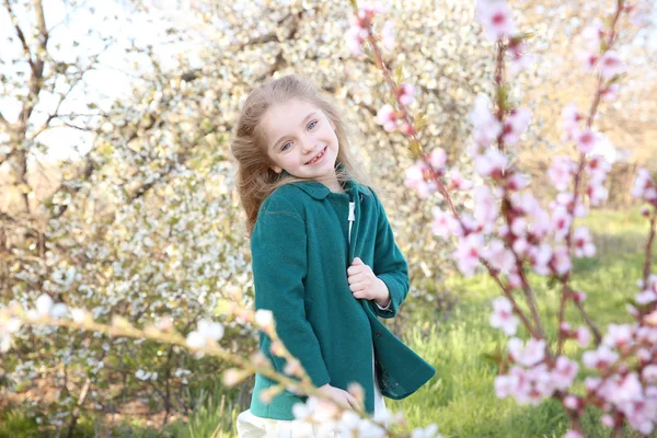 Klein meisje in de buurt van bloeiende boom — Stockfoto