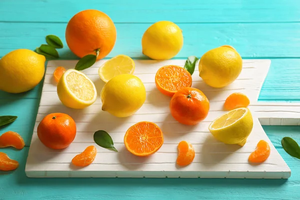 White cutting board with different citrus fruits — Stock Photo, Image