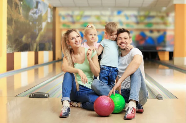 Happy family sitting on floor in bowling club Stock Image