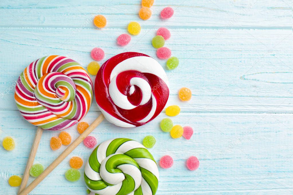 Candies and lollipops on wooden background