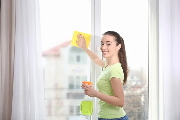 Молодая женщина моет окно — стоковое фото
