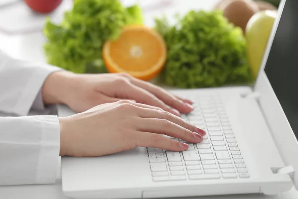 Junge Ernährungswissenschaftlerin arbeitet am Laptop — Stockfoto