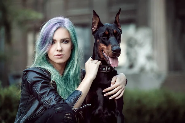 Idee trendy. Giovane donna con accento di colore menta in acconciatura e cane all'aperto — Foto Stock